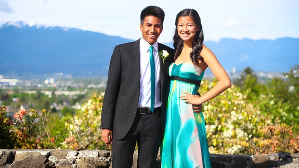 Una pareja se encuentra frente a un panorama montañoso en el terreno de la Eric Hamber Secondary School.