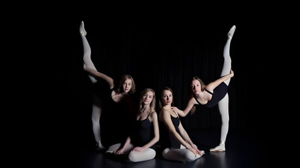 Cuatro bailarinas realizan una rutina acrobática sincronizada en el escenario de la Ernest Manning High School.