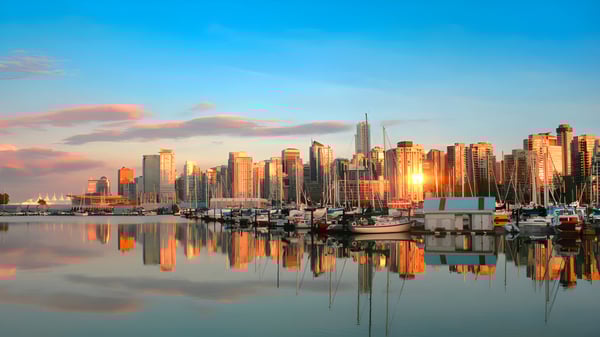 Un pintoresco paisaje urbano con altos rascacielos junto al agua cerca de la Ernest Manning High School al atardecer.