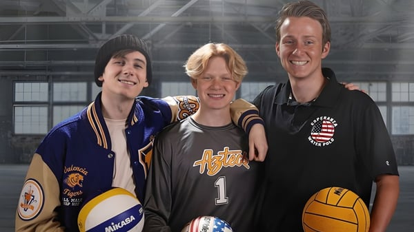 Tres estudiantes en camisetas deportivas están juntos en el gimnasio de la Esperanza High School.