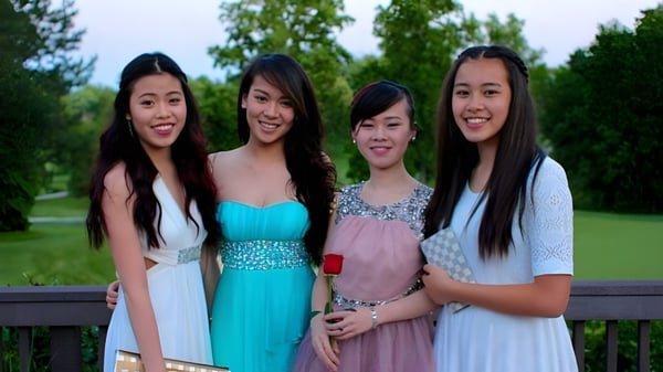 Cuatro estudiantes de la Fairfax Christian School están en una plataforma de madera rodeados de árboles y áreas de césped.