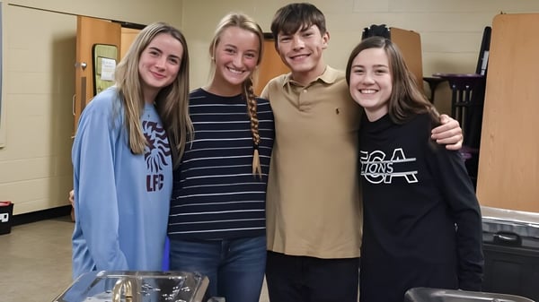 Cuatro estudiantes están sonriendo en un pasillo de la Faith Christian Academy en Pennsylvania.