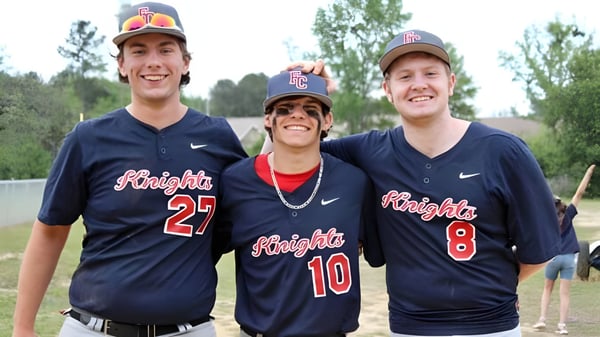 Tres estudiantes de la Faith Christian School en uniformes de béisbol están juntos en un campo al aire libre.