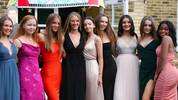 Un grupo de jóvenes estudiantes de la Farlington School posan frente a un fondo festivo.