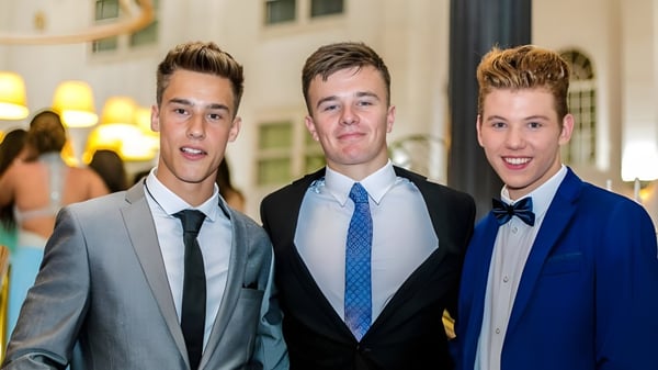 Tres jóvenes en ropa formal posan en el evento formal de la Farringtons School.