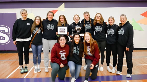 Un grupo de jóvenes atletas posan en uniformes deportivos en el gimnasio de la Fernie Secondary School.