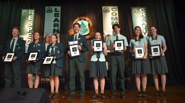 Estudiantes de la Ferny Grove State High School reciben premios en el escenario.