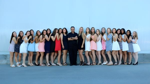 Un grupo de estudiantes de la FJ Brennan Catholic High School está frente a un fondo azul sólido.