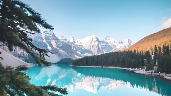 Un lago montañoso turquesa rodeado de montañas nevadas y bosques perennes en el terreno de la Forest Lawn High School.