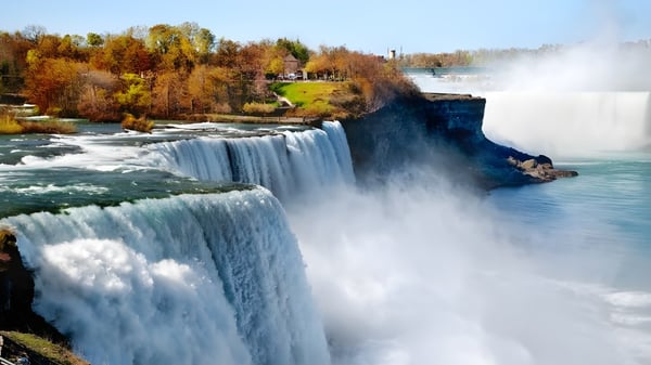 Una cascada fluye sobre un acantilado rocoso frente a un follaje otoñal en el terreno de la F.P. Walshe School.