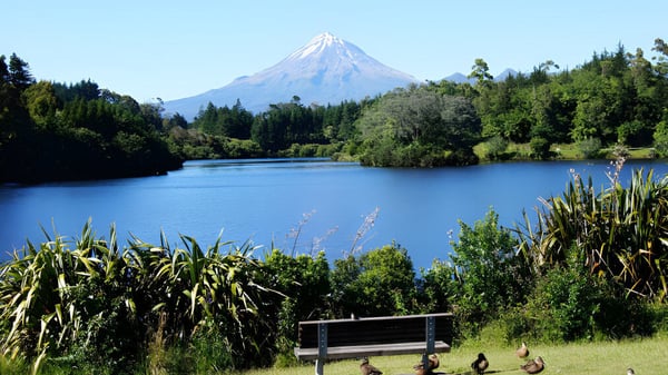 Un lago tranquilo frente a una cima montañosa nevada en el terreno del Francis Douglas Memorial College.