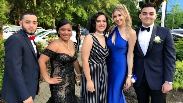 Cinco personas bien vestidas posan juntas frente a un fondo verde en el campus del Fraser Coast Anglican College.