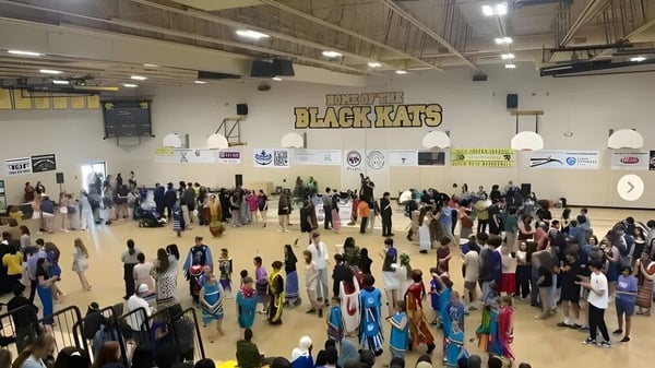 Muchos estudiantes se reúnen en el gimnasio de baloncesto de la Fredericton High School frente al letrero de Blackcats.