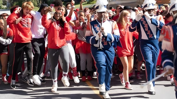 Un grupo de estudiantes de la Friends School of Baltimore participa en una parada y lleva principalmente ropa roja y blanca.