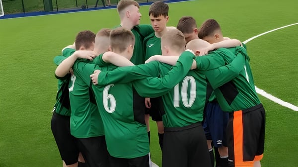 Un grupo de jóvenes futbolistas con camisetas verdes en el campo de la Gallen Community School.