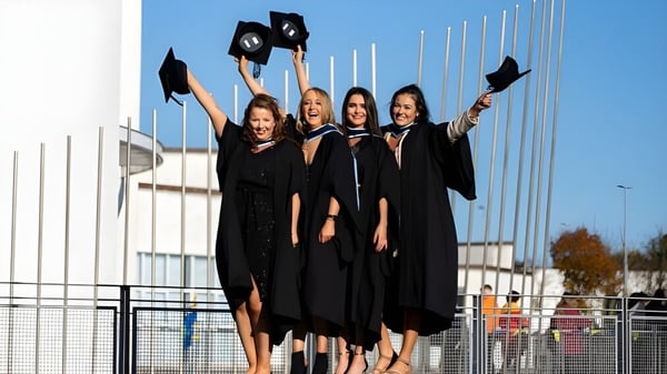 Un grupo de cuatro estudiantes celebra su graduación en el campus del Galway Community College.
