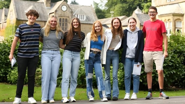 Un grupo de estudiantes se encuentra frente a un edificio con jardín en el campus de la Giggleswick School.