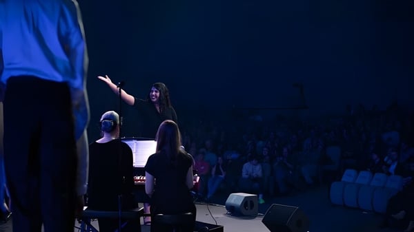 Una persona actúa en el escenario frente a un gran público en Gilbert Christian Schools.