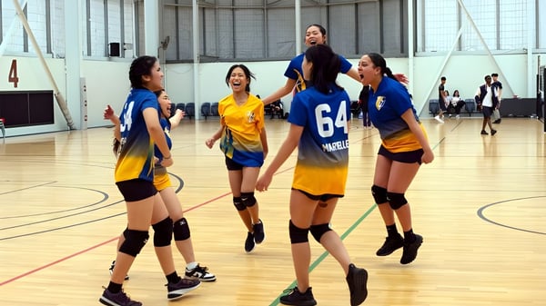 Un grupo de estudiantes del Gilmore College está en una cancha de baloncesto en un gran gimnasio.