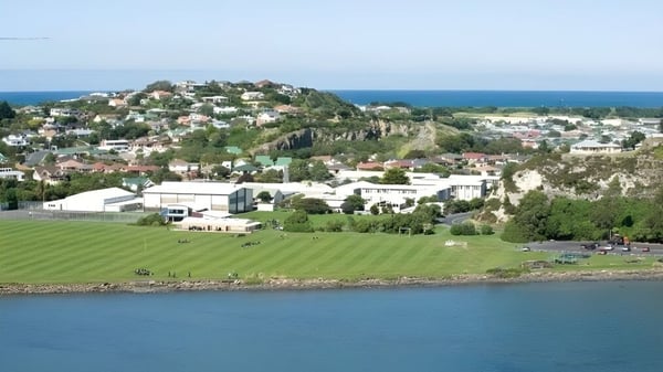 Vista de la ciudad costera con un campo verde y el mar de fondo cerca de la Gisborne Girls' High School.