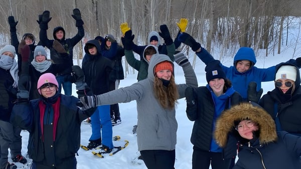 Estudiantes de Glengarry District High School están en el bosque nevado celebrando juntos.