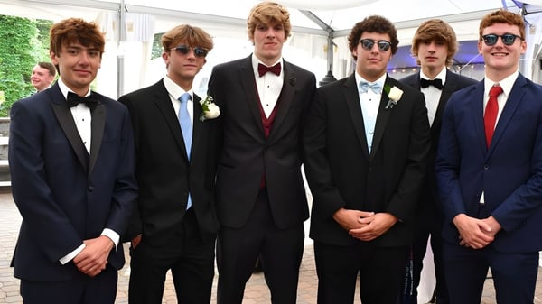 Un grupo de jóvenes en ropa formal está afuera en el terreno de la Glenstal Abbey School.