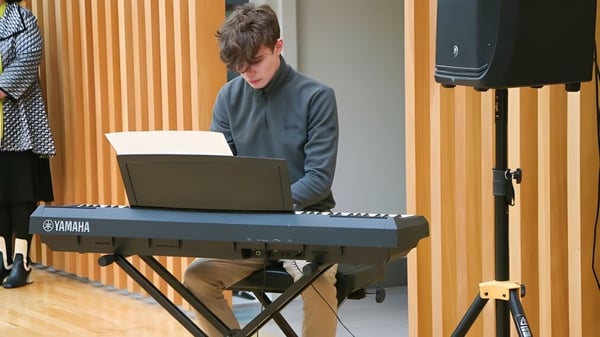 Un estudiante de la Glenstal Abbey School toca concentrado un teclado Yamaha con una laptop delante.