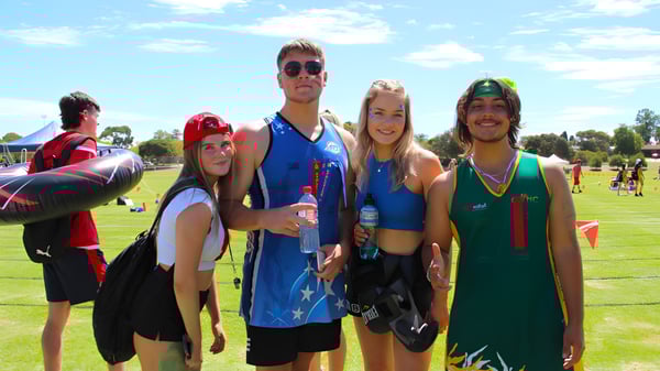 Un grupo de estudiantes de la Golden Grove High School posan en un prado bajo un cielo azul.