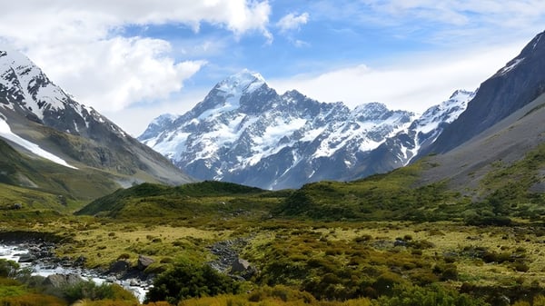 Un prado verde con montañas nevadas al fondo muestra el paisaje en la Gore High School.
