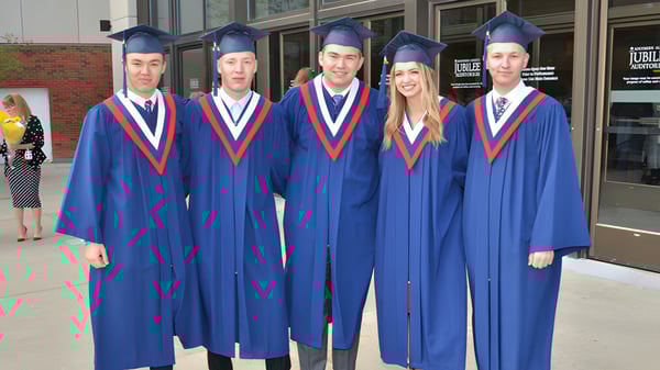 Cinco estudiantes de Grant Park High School llevan vestimenta de graduación azul frente a un edificio escolar.