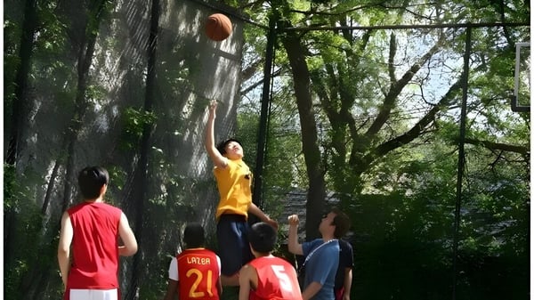 Estudiantes del Great Lakes College of Toronto juegan baloncesto en el área boscosa del campus escolar.