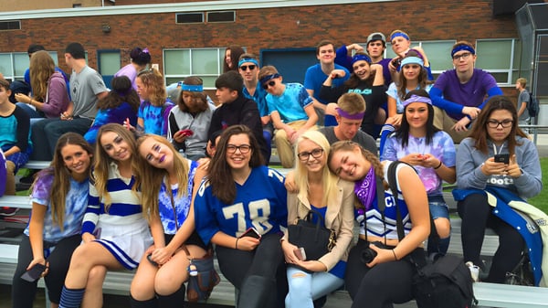 Un grupo de estudiantes de la Great Lakes District Secondary School está frente a un edificio de ladrillo.