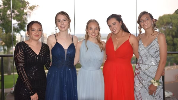 Cinco estudiantes del Greenwood College posan juntas al aire libre frente a árboles y un área cubierta de hierba.