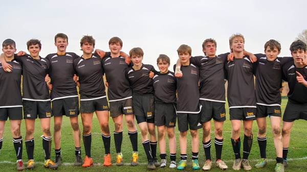 Un grupo de jóvenes futbolistas está de pie juntos en el campo de juego de Gresham’s School.