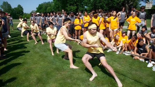 Estudiantes de la Groton School participan en una actividad grupal en el campo verde.