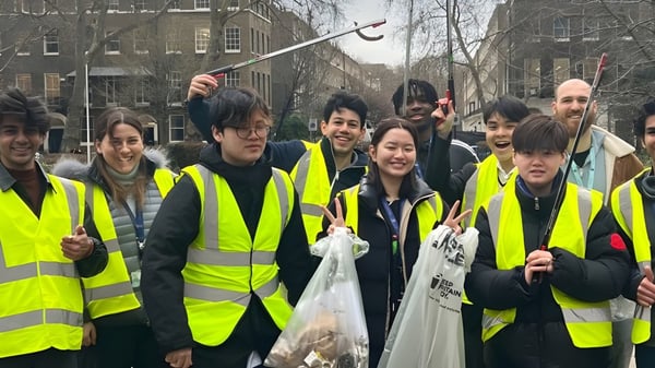 Los estudiantes de la Guildhouse School London están juntos en chalecos de seguridad en el área urbana.