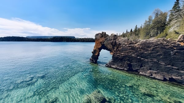 Una formación rocosa en arco se eleva sobre un lago claro en el terreno de la H.B. Beal Secondary School.