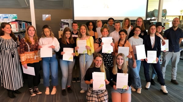 Estudiantes de la Hallett Cove School están juntas en un aula sosteniendo certificados.