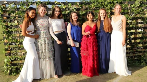 Un grupo de jóvenes mujeres en vestidos de fiesta está frente a un espacio verde en el Harrogate Ladies’ College.