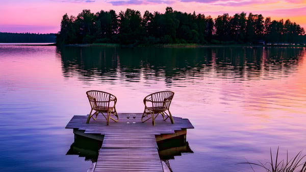 Un muelle con dos sillas de mimbre en un lago en el campus del Havergal College al atardecer.