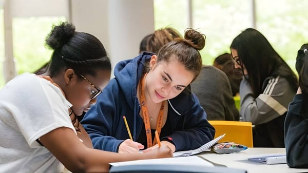 Un grupo de estudiantes trabaja juntos en el aula en el campus del Hazelwood College.