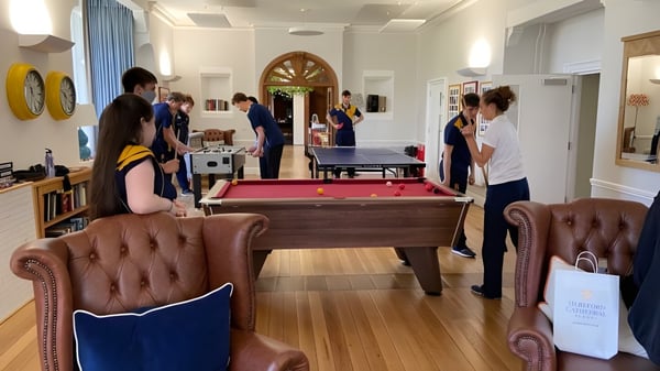 Estudiantes de la Hereford Cathedral School se reúnen en una sala de ocio con mesa de billar y asientos.