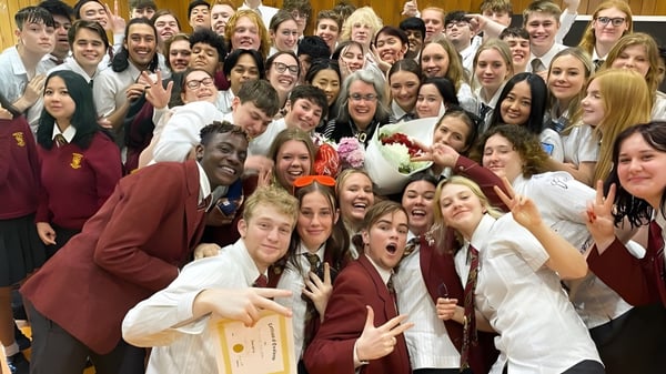 Un gran grupo de estudiantes del Heretaunga College posan juntos en uniforme escolar para una foto grupal.