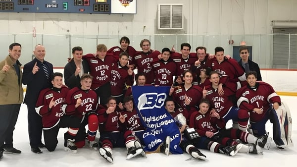 Un grupo de estudiantes de la Heritage Woods Secondary School posan juntos en una pista de hockey con camisetas y equipo.