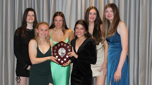 Alumnas de la Highworth Grammar School se reúnen vestidas de forma formal y sosteniendo un premio.