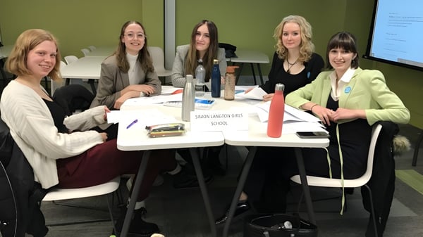 Un grupo de alumnas trabaja juntas en una mesa en el campus de la Highworth Grammar School.