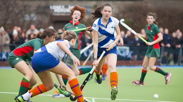 Estudiantes de la Holy Child Secondary School juegan un intenso partido de hockey sobre césped en el campo deportivo.
