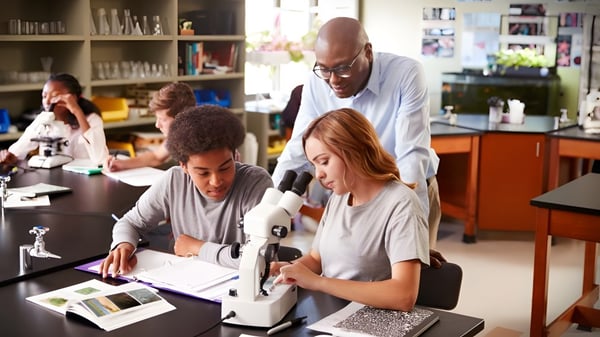 Estudiantes y profesores del Holy Rosary College trabajan juntos en un proyecto de investigación en el aula.