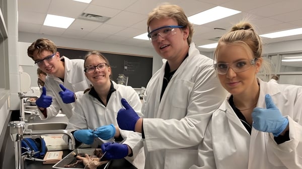 Estudiantes de la Holy Trinity Catholic High School examinan concentrados un experimento en el laboratorio.