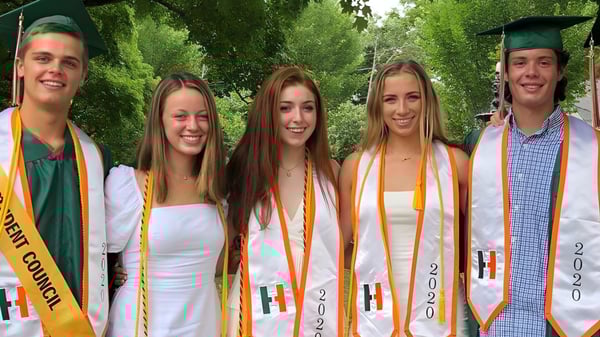 Cinco estudiantes en vestimenta de graduación están juntos en el área verde del campus de la Hopkinton High School.